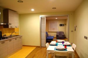 カターニアにあるSakè Family Suite - XL apartment in the heart of the Cityのキッチン(テーブル、椅子付)