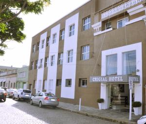 亚瓜龙Crigial Hotel的前面停着汽车的建筑物