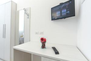 a vase on a counter with a television on a wall at Hotel Tourist Meuble in Rimini