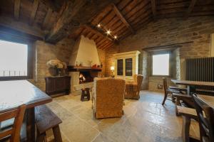 a living room with a fireplace and a table and chairs at Casalino di Sopra in Tredozio