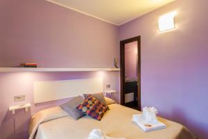 een slaapkamer met een bed met paarse muren bij Case Spazioscena - Euterpe in Castelbuono