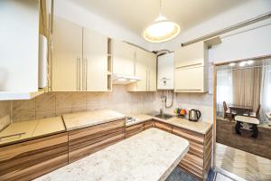 uma cozinha com armários brancos e uma mesa em Apartment in a city center! Krakivska,34 em Lviv