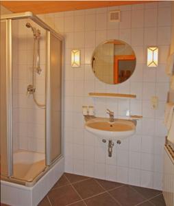 a bathroom with a sink and a shower and a mirror at Ferienwohnungen Haaser in Maurach +25 photos