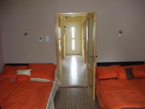 シオーフォクにあるAnikó Apartmanのオレンジのシーツが備わる客室内のベッド2台