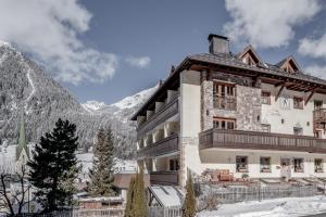 een gebouw in de bergen met sneeuw op de grond bij Hotel Garni Caroline in Ischgl