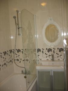 Haringey Victorian House في لندن: حمام مع دش وحوض استحمام ومغسلة