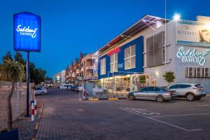 a street with cars parked in a parking lot at Peermont Metcourt Hotel in Francistown