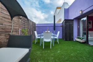 un patio con mesa y sillas en el césped en Atico soleado y céntrico, en Cádiz