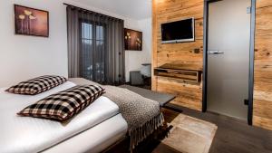 1 dormitorio con 1 cama con almohadas y TV en Hotel-Gasthof Adler, en Lindau