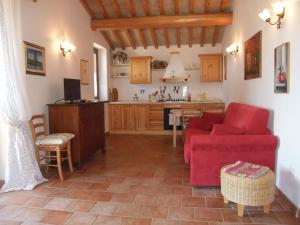 sala de estar con sofá rojo y cocina en Agriturismo Pian di Frattina, en Fabro