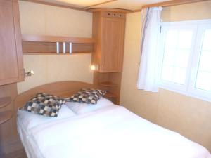 - une petite chambre avec un lit et une fenêtre dans l'établissement Mobilheim Seezauber, à Uttendorf