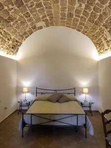 1 dormitorio con 1 cama con techo de piedra en B&B Macrina, en Noto