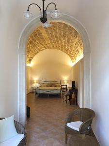 a room with a bed and chairs in a room at B&B Macrina in Noto