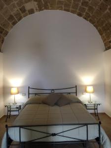 a bedroom with a bed with two lamps on two tables at B&B Macrina in Noto