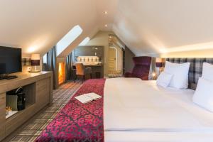 a hotel room with a large bed and a television at Lohmann's Romantik Hotel Gravenberg in Langenfeld +59 photos