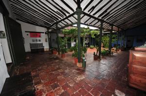 une chambre avec des plantes en pot sur un sol en briques dans l'établissement Hotel Mision Santa Barbara RNT 4799, à Barichara