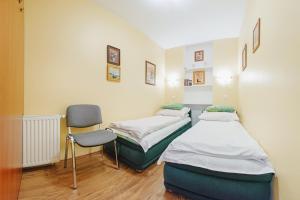 a hospital room with two beds and a chair at Apartamenty Sun & Snow Karpacz Skalna in Karpacz