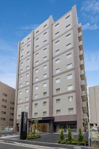 a large white building with a sign in front of it at Hotel Il Fiore Kasai in Tokyo