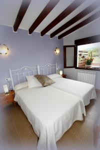 a large white bed in a room with a window at Apartamentos Fermín in Cangas de Onís