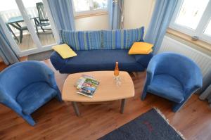 ein Wohnzimmer mit 2 blauen Stühlen und einem Tisch in der Unterkunft Villa Seerose - Appartement 07 in Ostseebad Sellin