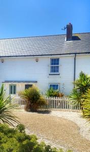 a white house with a fence in front of it at Sea Dragon in Rye