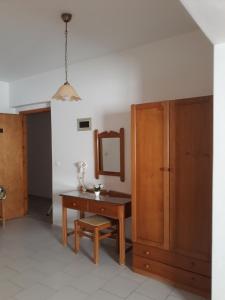 a room with a desk and a mirror and a cabinet at Amaryllis Hotel in Karpathos