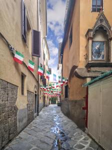 an alley with flags and flags hanging between two buildings at B&B due Borghi 3 in Pisa