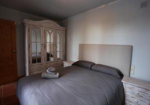 1 dormitorio con 1 cama grande y armario de madera en Chalet Adosado zona med/baja en Sierra Nevada