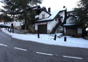 ein Haus mit Schnee an der Straßenseite in der Unterkunft Chalet Adosado zona med/baja in Sierra Nevada