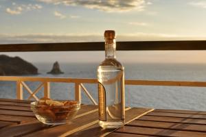 a bottle of wine on a table with a bowl of chips at Lido Sofia Holidays in Agios Gordios