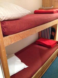 ティーニュにあるStudio cabine double balcon Tignes val claret ouvert toute l annéeの二段ベッド2組(赤と白の枕付)