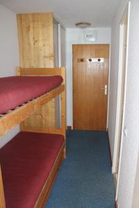 een kleine kamer met twee stapelbedden en een deur bij Studio cabine double balcon Tignes val claret ouvert toute l année in Tignes