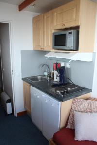 een kleine keuken met een spoelbak en een magnetron bij Studio cabine double balcon Tignes val claret ouvert toute l année in Tignes