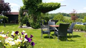 a table and chairs in a yard with flowers at B&B Vouwere in Mechelen