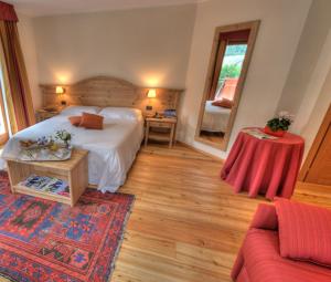 1 dormitorio con cama, mesa y sofá en Cresta Et Duc Hotel en Courmayeur