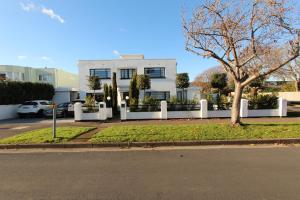 a white house with a tree in front of it at Milvil in Gosport