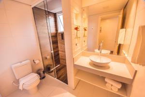 uma casa de banho com um WC, um lavatório e um chuveiro em Hospedaria das Brisas na Praia do Rosa