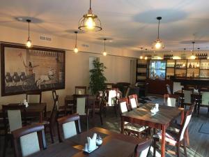 a restaurant with wooden tables and chairs and a bar at Hotel Jerevan in Druskininkai