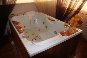 a white bath tub with glasses of wine and fruit at Troyan Plaza Hotel in Troyan