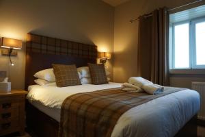 um quarto com uma cama grande e uma janela em Lochside hotel em Bowmore