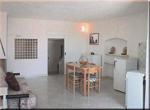 een keuken met een tafel en 2 koelkasten bij BLU MARINE CASA a 10mt dalla SPIAGGIA in Peschici