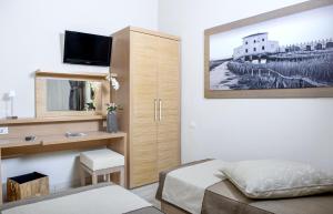 a small bedroom with a bed and a mirror at Hotel C'era Una Volta in Castiglione della Pescaia