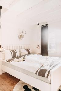 a white bedroom with a large white bed at Harz Cottage Emma in Bad Lauterberg