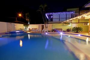 伊利亚贝拉Recanto Vicks Flats的夜间大型游泳池,灯光照亮