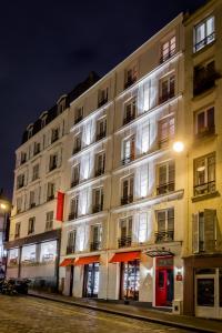 a large white building on a street at night at Hotel Scarlett in Paris