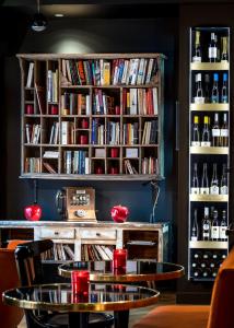 a dining room table with bookshelves filled with wine glasses at Hotel Scarlett in Paris