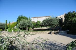 einen Garten mit Bäumen und ein Gebäude im Hintergrund in der Unterkunft PROVENCEguesthouse L'Agaçon in Forcalquier