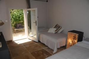 Schlafzimmer mit einem Bett und einer Glasschiebetür in der Unterkunft PROVENCEguesthouse L'Agaçon in Forcalquier