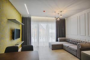 a living room with a couch and a tv at Nikolas Apartamentai - Birstono 7 in Druskininkai