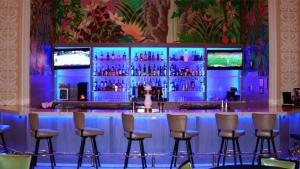 eine Bar in einem Restaurant mit Stühlen und TV in der Unterkunft Arlington Resort Hotel & Spa in Hot Springs